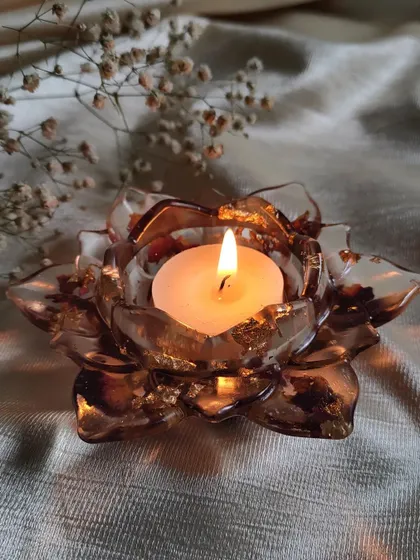 This lotus T-light holder is made with a warm brown tint and includes real rose petals. It has a lovely, earthy feel that is perfect for a cozy atmosphere.