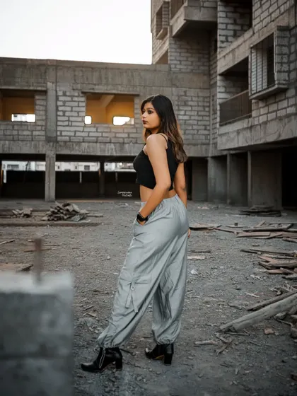 A full-length shot showcasing the model's street style outfit against the backdrop of the construction site, turning the urban landscape into a runway.