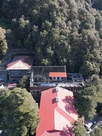 An aerial view showing the Parker Hall retrofit project nestled within the dense deodar forest of Landour. This perspective highlights the challenge and importance of building within a sensitive natural and historical context.