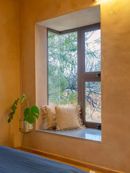 The corner window in the bedroom was designed to be a feature in itself. It provides a framed view of the trees outside, turning nature into living art. The deep sill also serves as a simple, contemplative seating spot.