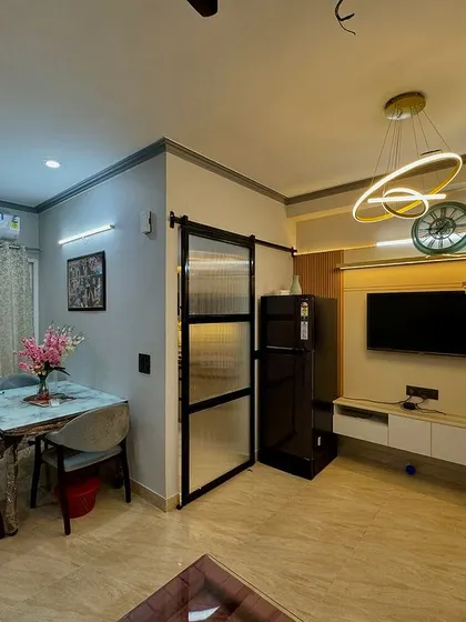 An overview of an open-plan living and dining area. A sliding barn door with a metal frame separates the kitchen, adding an industrial-chic element to the design.