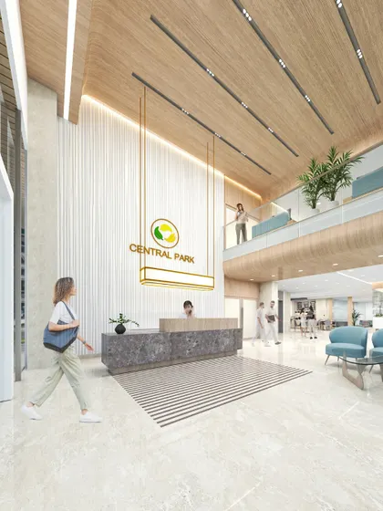 The upcoming Central Park Polyclinic is a 25,000 sq. ft. facility designed for a modern, human-centric approach to outpatient care. The rendering shows a reception area with warm wood finishes and a calm, neutral palette to support a soothing environment.
