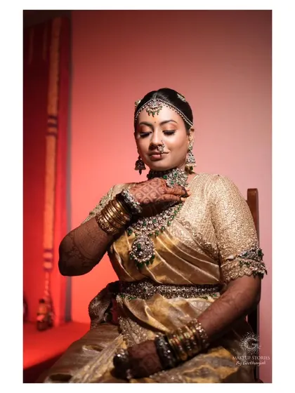 Nidhi in a moment of quiet reflection before her wedding. The makeup is classic and timeless, ensuring she looks back on these photos with love for years to come.