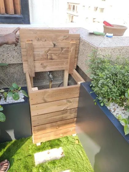 Rooftop gardens often have utility items like pipes and water tanks. Here, I designed a custom wooden box to cleverly hide an unsightly pipe, integrating it seamlessly into the garden design.
