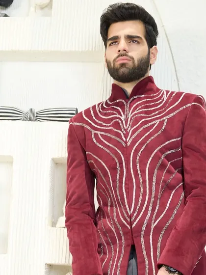 A bold statement in crimson velvet. This bandhgala jacket features striking silver embroidery, designed for the man who is not afraid to stand out during the holiday season.