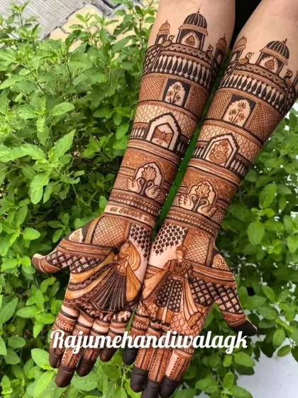 This design features dancing bride figures on the palms, with royal architecture on the arms. The backdrop of green leaves makes the henna color stand out.