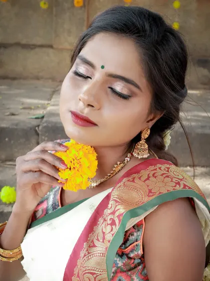 A natural makeup look for an Onam-themed shoot. The makeup is kept subtle and glowing to complement the classic white and gold saree, letting her dusky beauty shine.