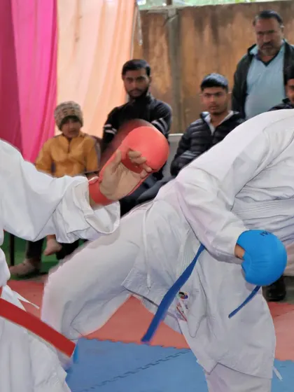 A close-up action shot of a kick during a kumite match. This is the reality of competition.