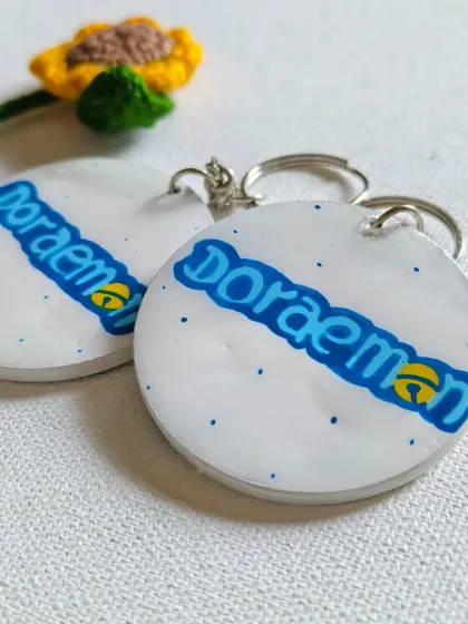 Another option for Doraemon fans. This keychain features the classic Doraemon logo, hand-painted in its signature blue and yellow colors.