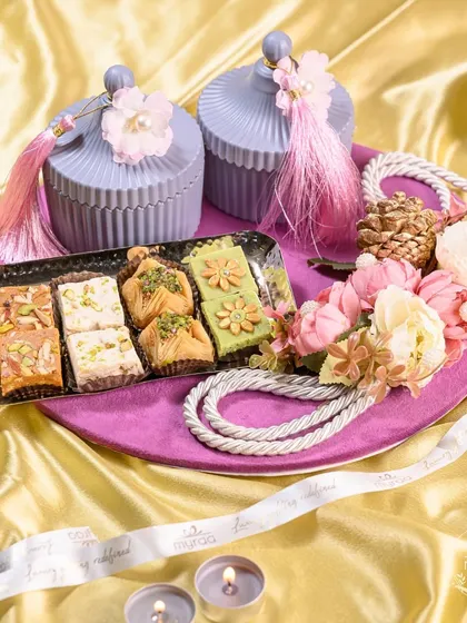 My festive hampers are designed to capture the spirit of celebration. This Diwali platter combines traditional Indian sweets like baklava and barfi with elegant, reusable jars and floral arrangements, making it a perfect centerpiece and gift.