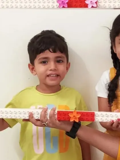 A duplicate image of two students in a frame they built, capturing a moment of shared fun and accomplishment.