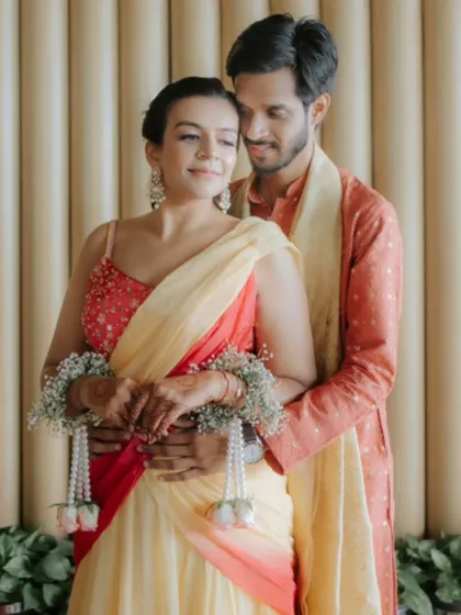 A tender embrace between the couple during their Haldi ceremony, their colourful outfits creating a beautiful contrast.