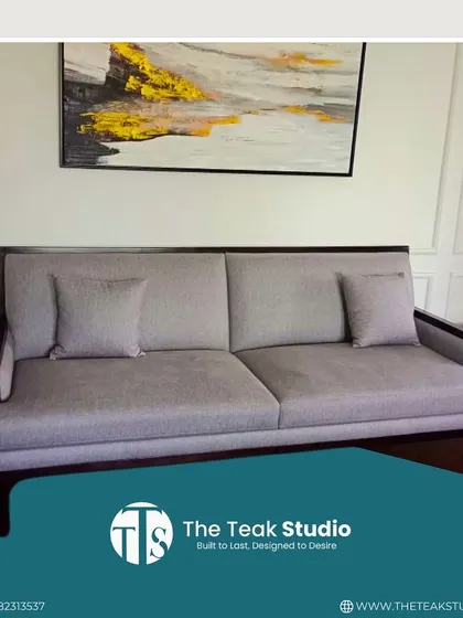 A simple yet elegant three-seater sofa with a dark wood frame and light grey upholstery. This versatile piece is perfect for creating a clean, minimalist look in any living room.