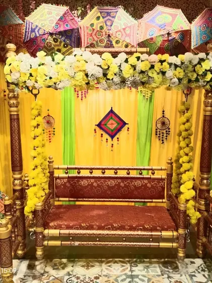 This is our classic Haldi ceremony setup with a traditional wooden jhoola (swing). We use colorful Rajasthani umbrellas, marigold garlands, and bright yellow drapes to create a fun and authentic atmosphere.