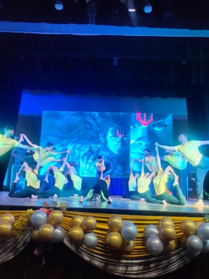 Our training opens doors to amazing opportunities. Here, my students are performing a complex group yoga sequence on stage at the Shah Auditorium. This is the level of skill and confidence you will build with us.