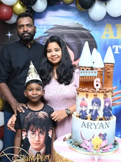 A happy family celebrating with a Harry Potter themed cake that perfectly matches our decorations. We can coordinate with your baker to ensure a cohesive look.