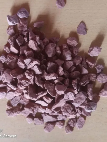 Unpolished red stone chips, which can add a pop of color to garden designs.