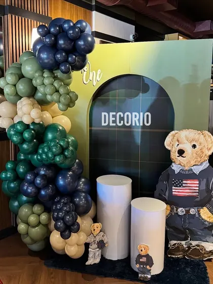 The main decoration for the Polo Ralph Lauren teddy bear theme. It includes a balloon arrangement in sophisticated greens and blues, and a large teddy bear cutout dressed in classic American style.