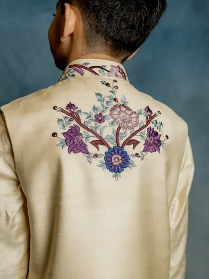 A view of the back of our peacock Bundi jacket, showing the beautiful embroidery that continues all around. We believe every angle should be picture-perfect.