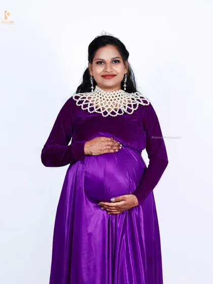 A final look at the purple gown styled with the pearl collar, showing its versatility for a more dressed-up, formal maternity look.