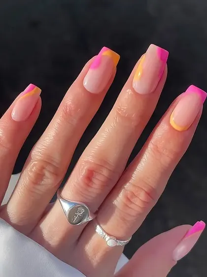 A fun, summery French manicure with a twist. This design features squared nails with a colorful combination of pink and yellow abstract tips for a bright and playful look.