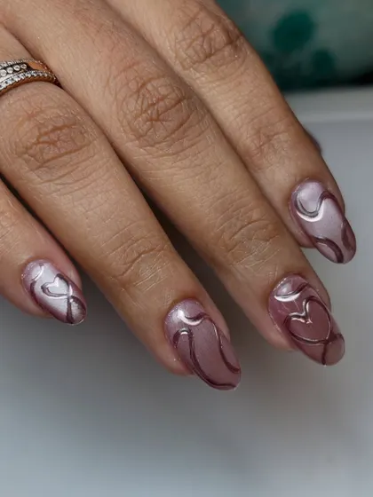 Magnetic charm with a touch of love. This design uses a shimmery cat-eye polish as a base for delicate, 3D chrome hearts and swirls.