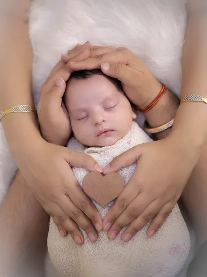 A variation of the classic newborn hands shot, with the baby wrapped snugly and parents' hands forming a heart. Each family's hands tell a different story, and I love capturing these unique details.