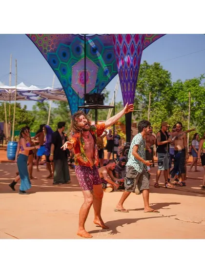 A wide shot of the dance floor, showing the energy and movement of the crowd under the colorful festival canopy.