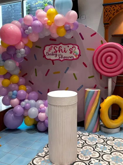 The full view of our Candyland-themed baby shower backdrop. A donut-inspired background with sprinkles, a pastel balloon arch, and giant candy props create a fun and memorable photo spot.
