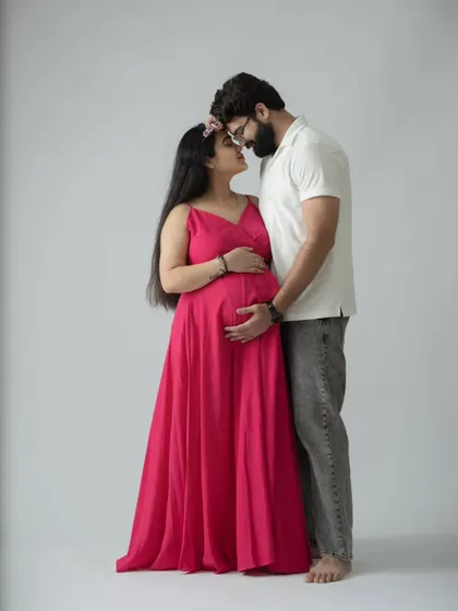A classic and romantic pose, with the couple sharing a quiet moment forehead-to-forehead. This full-length shot showcases the beautiful pink gown.