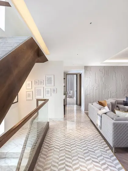 The living area in our Nordic-inspired Amara project, featuring clean lines, natural materials, and a soothing color palette. The chevron-patterned floor and textured wall add subtle visual interest to the calm and welcoming space.