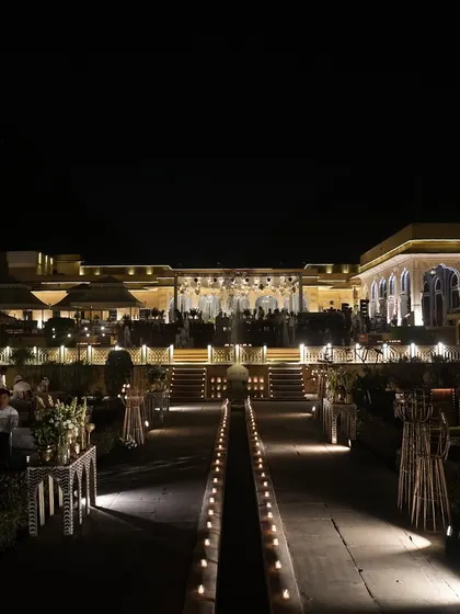 The grand setting of our 'Retro Sufi' sangeet night, with candle-lit pathways leading to the main event area in Jaipur's historic garden.