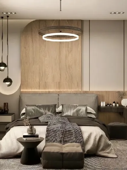 A contemporary bedroom featuring a unique circular chandelier and pendant lights. The combination of wood paneling and a soft grey headboard creates a balanced and harmonious design.