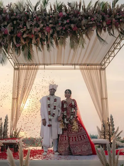 A beautiful portrait of the couple on their wedding stage, framed by the sunset and showered in confetti.