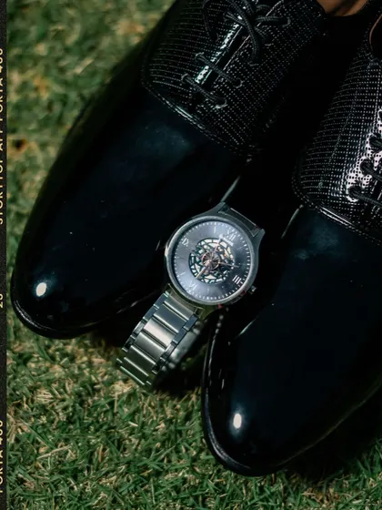 A detailed shot of the groom's watch and shoes.