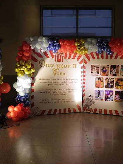 A custom backdrop designed like a vintage circus poster, displaying photos from the child's first year.
