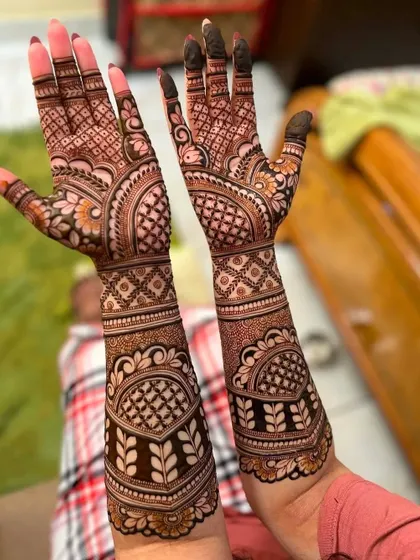 A different pose showing the same rich henna stain. The intricate leaf and checkerboard patterns are sharp and clear.