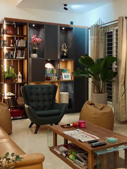 This cozy living room corner features a custom-built library and display unit with integrated lighting. The combination of open shelves and closed cabinets offers a perfect balance of storage and style.