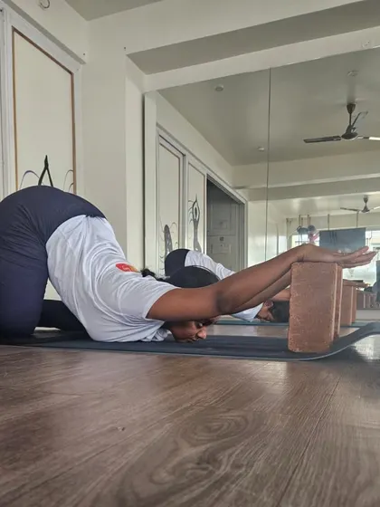 Using props is key to a safe practice. A TTC student uses blocks in Anahatasana (Melting Heart Pose) to deepen the shoulder stretch while protecting the joints.