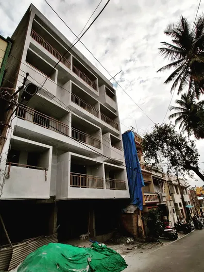 The LR Residency apartment building in Devaiah Park, pictured during the final stages of construction, showcasing its monolithic form and recessed balconies.