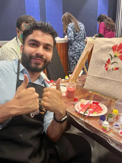 A participant gives a thumbs-up, happy with his progress on his tote bag. The enthusiasm in my workshops is contagious!
