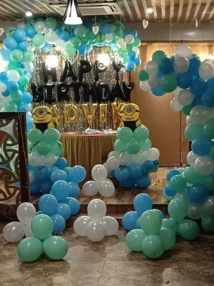 A wider view of the Minions party, showing how the balloon decorations frame the central party area.