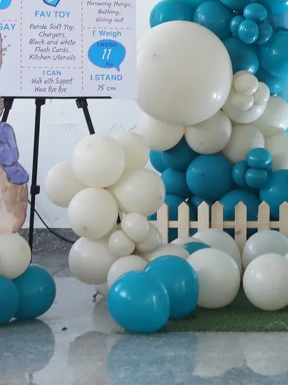 A milestone board and balloon cluster from a Peter Rabbit-themed party. The custom board is a great way to share fun facts about the birthday boy.
