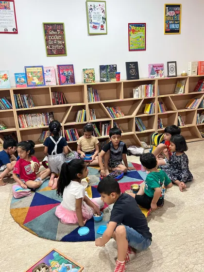 After the hard work of making puppets, the kids gather on the floor to play and interact, beginning to form the stories they will later perform.