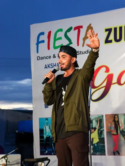 Taking the mic as the MC for the Fiesta Zumba Fitness Event. We don't just lead the dancing; we host and emcee to ensure the event runs smoothly and the energy never drops.