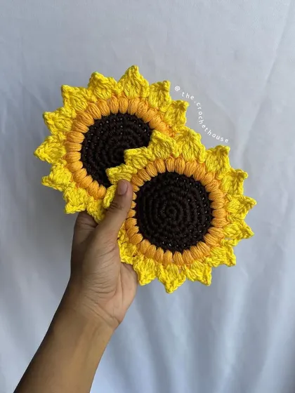 A simple shot of two of our sunflower coasters. The detailed stitching and vibrant colors showcase the quality of our handmade work.