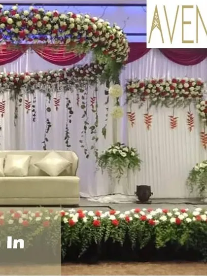 For a grand and traditional look, we designed this reception stage with a massive floral arch of red and white roses. The cascading floral strings and draped backdrop create a sense of opulence and celebration.