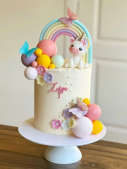 Another take on the unicorn theme, this cake features a pastel rainbow, delicate butterflies, and colorful spheres for a fun, modern look.