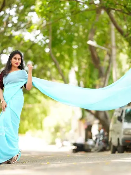 The sky-blue saree's pallu is tossed to create a beautiful, flowing shape.