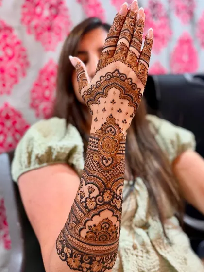 A lovely bride-to-be posing with her full-arm engagement mehendi.
